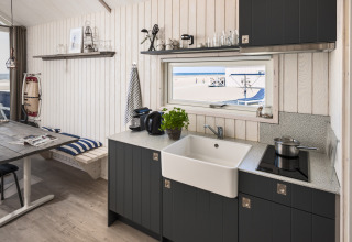 Casa sulla spiaggia glamping a L'Aia con cucina moderna e vista sulla spiaggia dalla finestra.