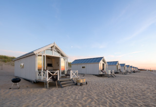 Luxury glamping beach houses in The Hague set on sandy shores, offering a unique and comfortable stay.