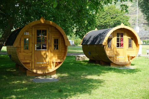 Dos alojamientos glamping de lujo en forma de barril en Mosel Islands, situados bajo árboles en verano.