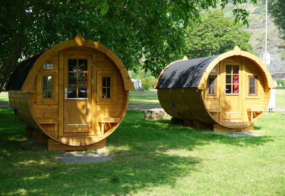 Due alloggi glamping di lusso a forma di botte su Mosel Islands, immersi nel verde, giornata estiva.