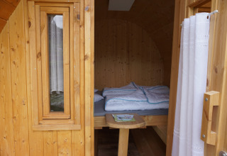 Ingresso di una botte di legno di lusso per dormire nelle Mosel Islands, con letto confortevole all'interno.