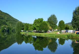 Campsite by the river with trees, caravans, and tents at Mosel Islands - Luxe slaapvaten aan de Moezel.