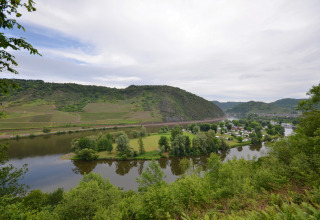 Vista panoramica su Mosel Islands glamping lungo il fiume, colline verdi e area campeggio in lontananza.