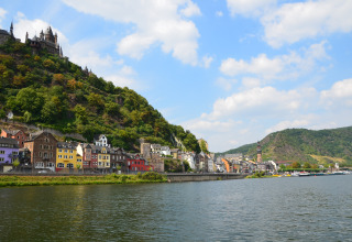 Kleurig dorp aan de rivier met kasteel op de heuvel bij Mosel Islands - Luxe slaapvaten aan de Moezel.