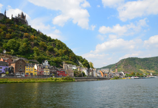 Bunte Häuser und eine Burg am Hang an einem Fluss, nahe Mosel Islands - Luxe slaapvaten aan de Moezel.