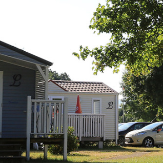 Alojamiento glamping en Camping Tunisee - Stacaravans Baden-Württemberg con cabañas y coches estacionados.