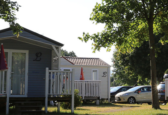 Glamping accommodatie bij Camping Tunisee - Stacaravans Baden-Württemberg met chalets en geparkeerde auto's.