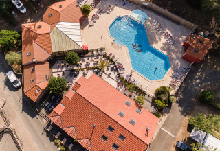 Vista aérea de Camping Les Cyprès - Glampingtenten Vendée con piscina, tumbonas y naturaleza alrededor.