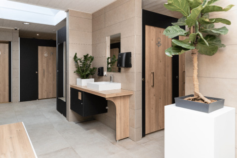 Moderne badkamer bij Camping Les Cyprès - Glampingtenten Vendée, met houtaccenten en groene planten.