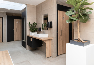 Modernes Badezimmer bei Camping Les Cyprès - Glampingtenten Vendée mit Holzdetails und Zimmerpflanzen.