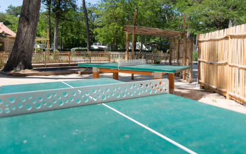 Outdoor ping pong tables with wooden fencing at Camping Les Cyprès - Glampingtenten Vendée glamping site.