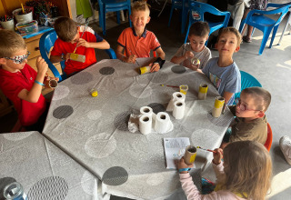 Niños pintando rollos de cartón en un taller creativo en Camping Les Cyprès - Glampingtenten Vendée.