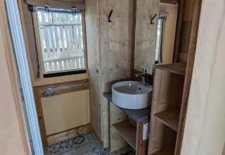Badezimmer im Glampingtent bei Camping Les Cyprès - Glampingtenten Vendée mit Holz und Fliesenboden.