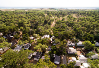 Vista aérea de Camping Les Cyprès - Glampingtenten Vendée con casas móviles y árboles junto a la costa.