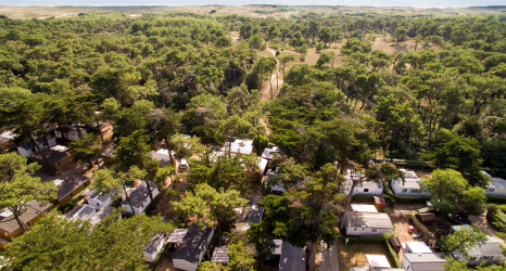 Vue aérienne du Camping Les Cyprès - Glampingtenten Vendée, entouré d’arbres et de mobil-homes près de la côte.