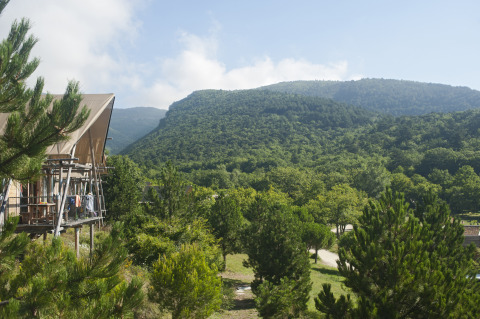 Hébergement glamping au Village Huttopia Dieulefit avec vue sur les collines vertes en Drôme-Provence.