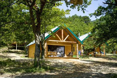 Cabanes en bois pour le glamping entourées d’arbres au Village Huttopia Dieulefit – Glamping Drôme-Provence.