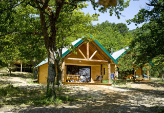 Houten glampinghuisjes tussen de bomen bij Village Huttopia Dieulefit – Glamping Drôme-Provence in Frankrijk.
