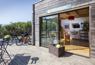 Uitzicht op het gidsenbureau met fietsen en sportuitrusting bij Village Huttopia Dieulefit – Glamping Drôme-Provence.