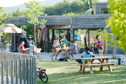 Familias y amigos disfrutan al aire libre en Village Huttopia Dieulefit – Glamping Drôme-Provence, rodeados de naturaleza.