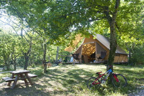 Glamping accommodatie Village Huttopia Dieulefit – Glamping Drôme-Provence met tent, fietsen en picknicktafel.