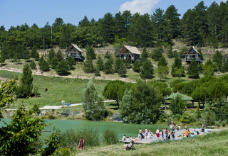Village Huttopia Dieulefit, alojamiento glamping en Drôme-Provence con cabañas y personas junto al lago.