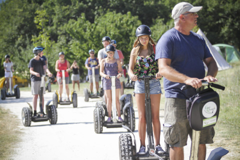 Groep mensen maakt een Segway-tocht bij Village Huttopia Dieulefit – Glamping Drôme-Provence in het groen.