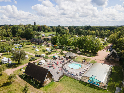 Vue aérienne d’Huttopia Calvados-Normandie avec piscines, tentes glamping et espaces verts en Normandie.