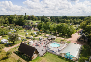 Vue aérienne d’Huttopia Calvados-Normandie avec piscines, tentes glamping et espaces verts en Normandie.