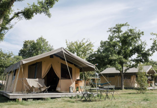 Glamping-indkvartering med luksustelte og møbleret terrasse hos Huttopia Calvados-Normandie i Frankrig.