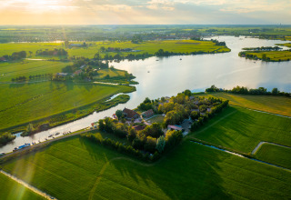 Luchtfoto van Pean Buiten - Natuurhuisjes Friesland glamping, omringd door velden en waterwegen.