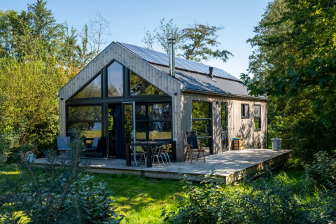 Pean Buiten - Natuurhuisjes Friesland: Authentiek glampinghuisje met veranda, grote ramen en omringd door natuur.