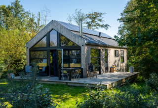 Pean Buiten - Natuurhuisjes Friesland: Rifugio glamping accogliente con terrazza, ampie finestre e natura verde.
