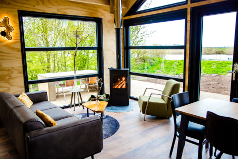 Moderne Glamping-Unterkunft Pean Buiten - Natuurhuisjes Friesland mit großen Fenstern und Naturblick.