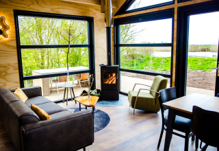 Moderne glamping accommodatie Pean Buiten - Natuurhuisjes Friesland met grote ramen en zicht op natuur.