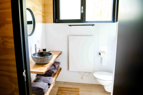 Moderne badeværelse i glampingindkvartering Pean Buiten - Natuurhuisjes Friesland med træelementer.