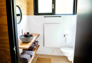 Moderne badeværelse i glampingindkvartering Pean Buiten - Natuurhuisjes Friesland med træelementer.