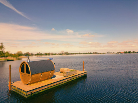 Træhytte på flydende platform ved søen hos Pean Buiten - Natuurhuisjes Friesland, glamping i Holland.