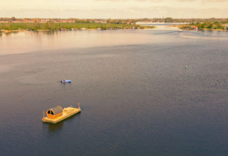 Floating glamping cabin on a lake at Pean Buiten - Natuurhuisjes Friesland, surrounded by peaceful nature.