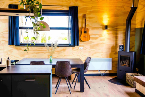 Modernes Glamping bei Pean Buiten - Natuurhuisjes Friesland mit gemütlicher Einrichtung und Holzofen.