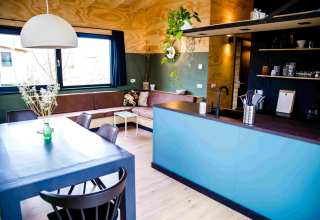 Hébergement glamping moderne avec cuisine ouverte, table à manger et canapé chez Pean Buiten - Natuurhuisjes Friesland.
