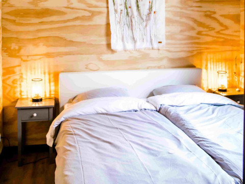 Alloggio glamping accogliente presso Pean Buiten - Natuurhuisjes Friesland con letti gemelli e luce soffusa.