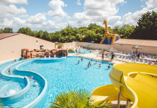 Piscina all'aperto con scivolo giallo, lettini e grande giraffa al Camping Village de la Guyonnière.