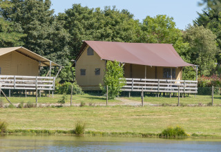 Glamping-Unterkunft in Safarizelten auf dem Camping Village de la Guyonnière, Vendée, mit Blick auf einen See.