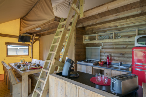 Interieur van een safaritent glamping bij Camping Village de la Guyonnière, met keuken en eetruimte.