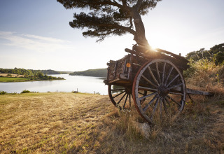 Charmerende udsigt over søen fra Camping Village de la Guyonnière – Safaritenten Vendée med gammel vogn.