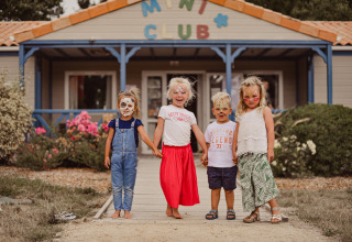 Vier Kinder mit Gesichtsbemalung stehen vor dem Miniclub des Camping Village de la Guyonnière in Vendée.