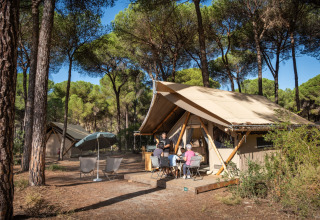 Alloggio glamping nell'Huttopia Parque de Doñana – Glamping Andalusia con persone vicino alla tenda.
