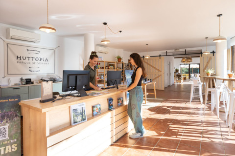 Reception di Huttopia Parque de Doñana glamping, ambiente luminoso e staff cordiale in Andalusia, Spagna.