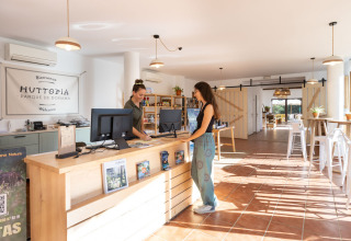 Recepción en Huttopia Parque de Doñana glamping, ambiente luminoso y personal amable en Andalucía, España.